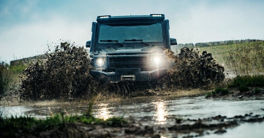 Adventure car driving through deep, thick mud